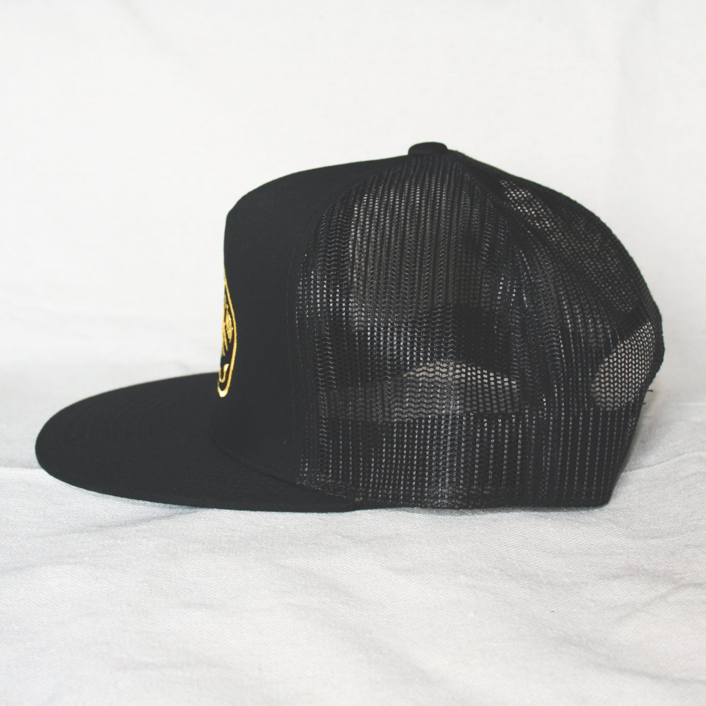 Black snapback with 'Born to Lose' gold embroidery on the front panel. High-profile, flat brim trucker cap with breathable mesh. Made of 65% polyester, 35% cotton. Structured 5-panel, 4” crown. Finished in Alberta, Canada.