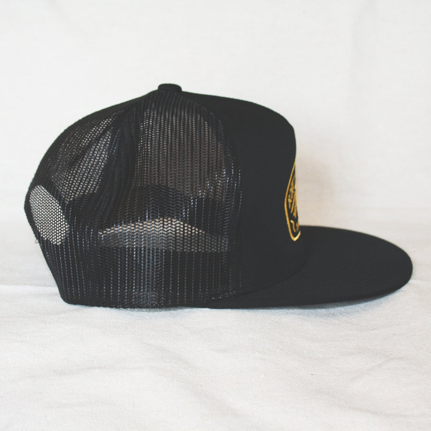 Black snapback with 'Born to Lose' gold embroidery on the front panel. High-profile, flat-brim trucker cap with breathable mesh. Made of 65% polyester, 35% cotton. Structured 5-panel, 4” crown. Finished in Alberta, Canada.