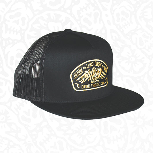 Black snapback with 'Born to Lose' gold embroidery on the front panel. High-profile, flat brim trucker cap with breathable mesh. Made of 65% polyester, 35% cotton. Structured 5-panel, 4” crown. Finished in Alberta, Canada.