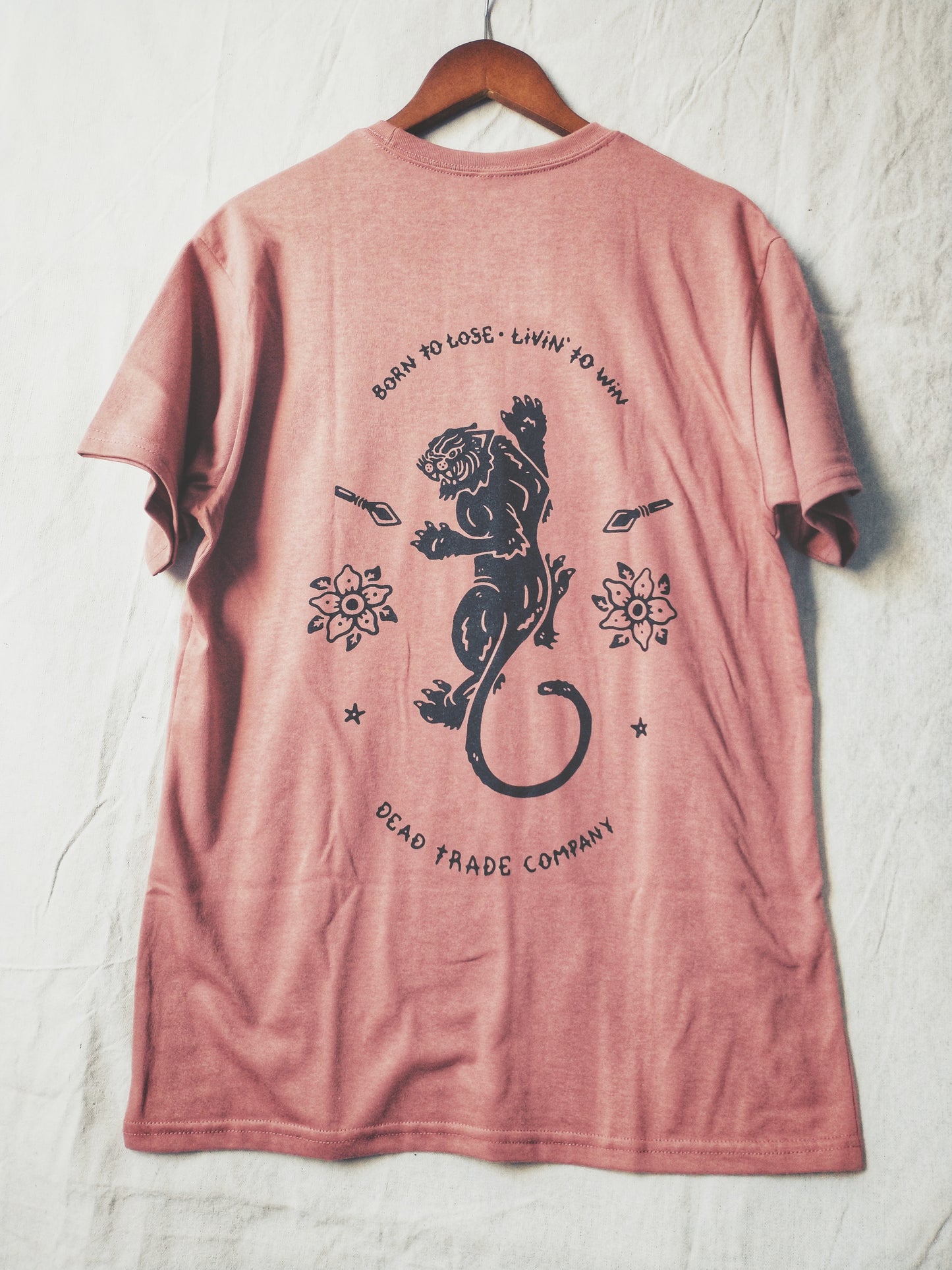 Dusty rose graphic t-shirt made in Canada from a soft 50/50 poly-cotton blend, featuring a bold hand-drawn design of a fighting panther surrounded by spears and flowers, screen printed in black ink. Perfect for those who appreciate lowbrow, traditional tattoo artwork.