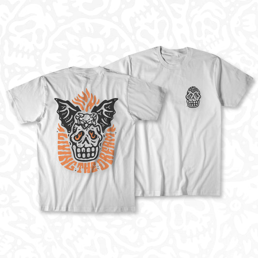 White graphic t-shirt made in Canada from a soft 100% ring-spun cotton, featuring a bold hand-drawn design of a broken skull with a winged demon peaking out the top, screen printed in black and bright orange ink. Perfect for those who appreciate lowbrow, tattoo-style artwork.