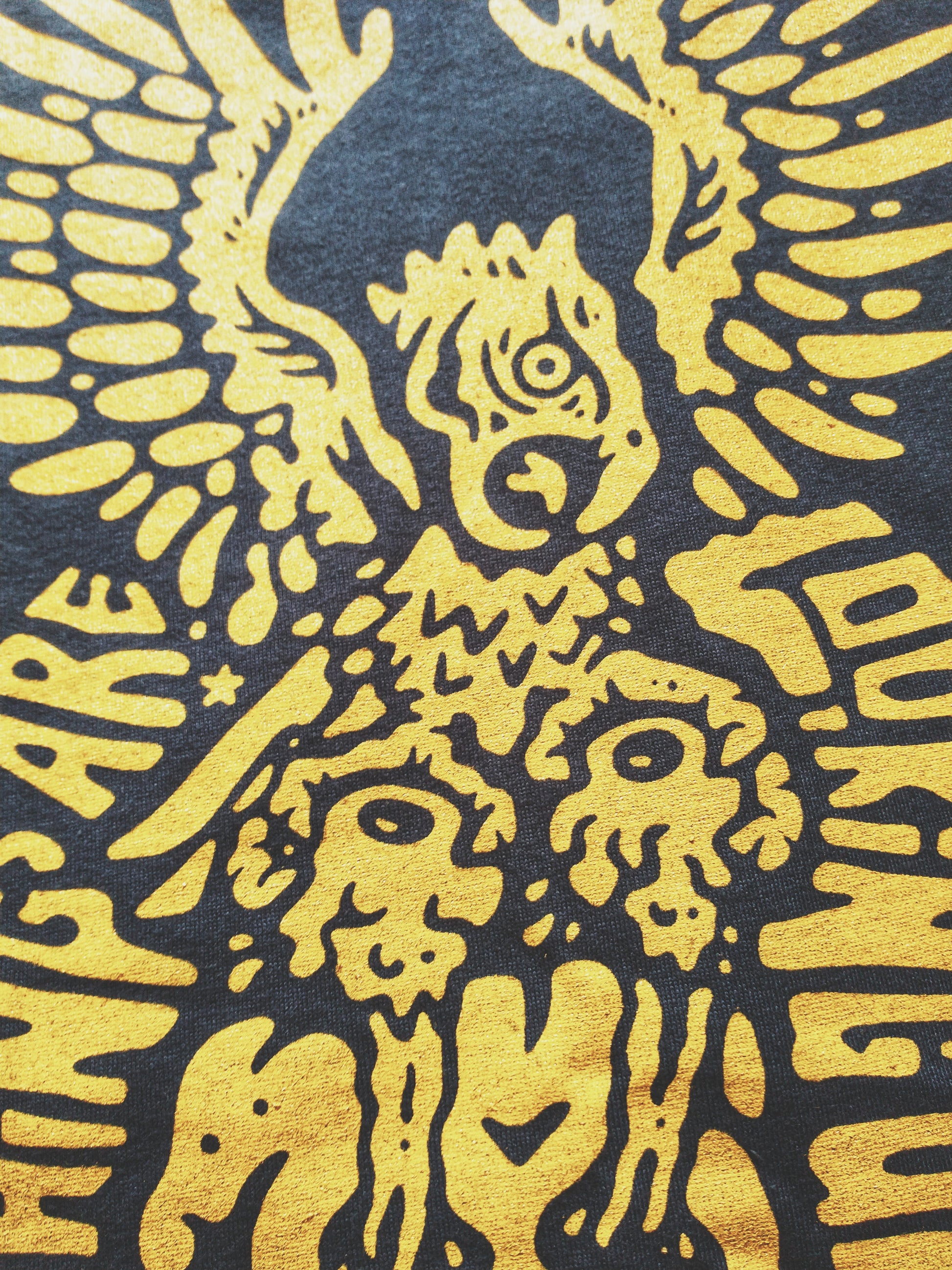 Charcoal graphic t-shirt made in Canada from a soft 50/50 poly-cotton blend, featuring a bold hand-drawn design of an eagle pulling eyeballs from a skull, screen printed in vibrant yellow ink. Perfect for those who appreciate lowbrow, edgy artwork.