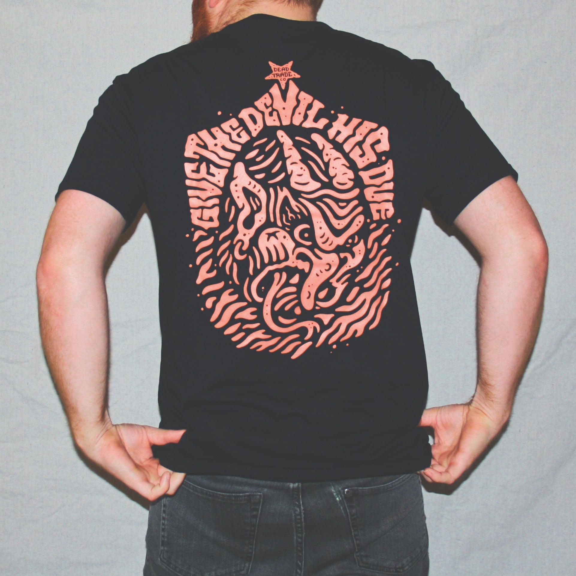 Black graphic t-shirt made in Canada from a soft 100% ring-spun cotton, featuring a bold hand-drawn design of a nasty, horned devil head, screen printed in red-orange ink. Perfect for those who appreciate lowbrow, tattoo-style artwork.