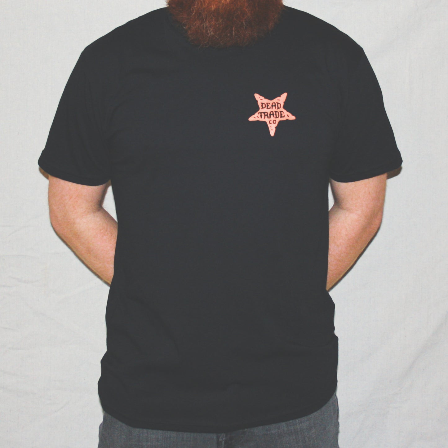 Black graphic t-shirt made in Canada from a soft 100% ring-spun cotton, featuring a bold hand-drawn design of a nasty, horned devil head, screen printed in red-orange ink. Perfect for those who appreciate lowbrow, tattoo-style artwork.