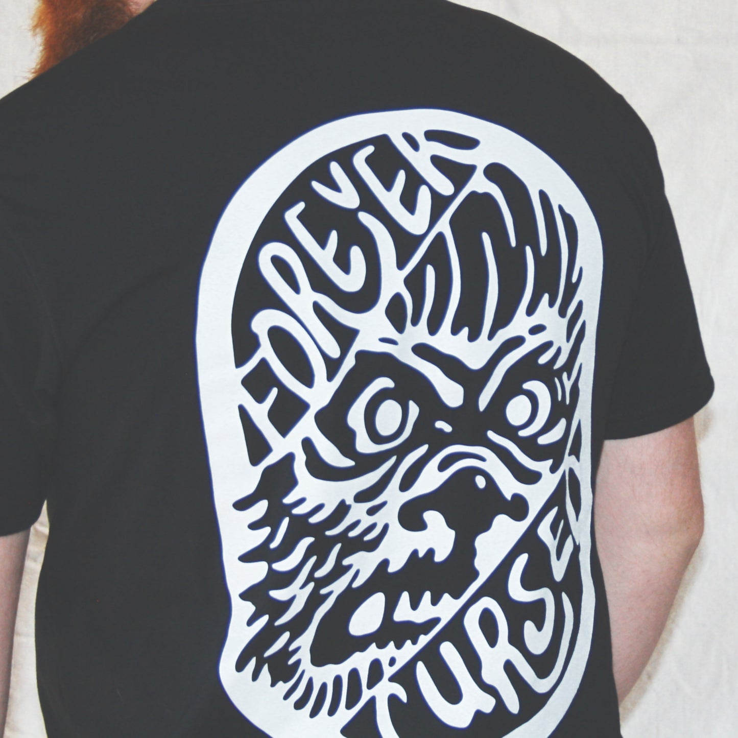 Black graphic t-shirt made in Canada from a soft 100% ringspun cotton, featuring a bold hand-drawn design of an angry werewolf face between the words “forever cursed”, screen printed in white ink. Perfect for those who appreciate lowbrow, horror-inspired artwork.