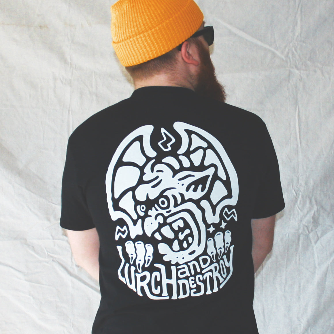 Black graphic t-shirt made in Canada from a soft 100% ring-spun cotton, featuring a bold hand-drawn design of an angry gargoyle growling over the words “lurch and destroy,” screen printed in white ink. Perfect for those who appreciate lowbrow, horror-inspired artwork.