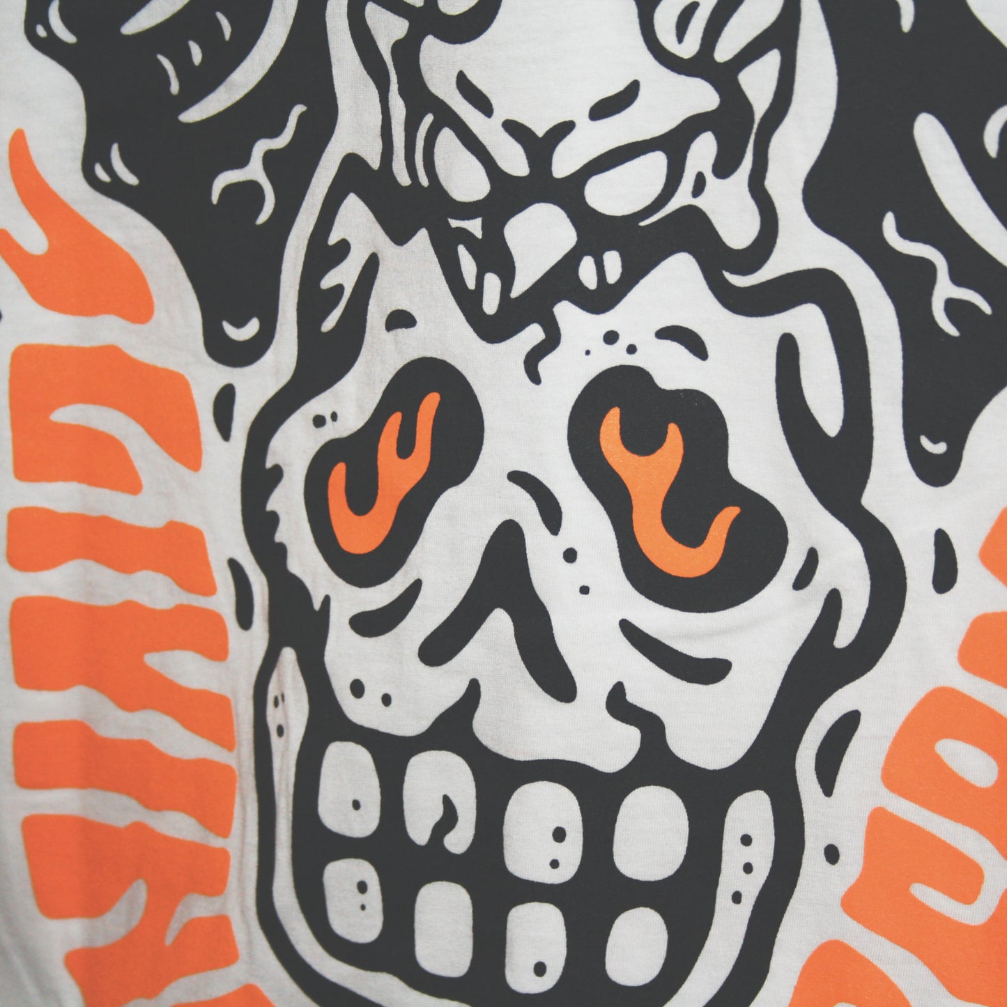 White graphic t-shirt made in Canada from a soft 100% ring-spun cotton, featuring a bold hand-drawn design of a broken skull with a winged demon peaking out the top, screen printed in black and bright orange ink. Perfect for those who appreciate lowbrow, tattoo-style artwork.