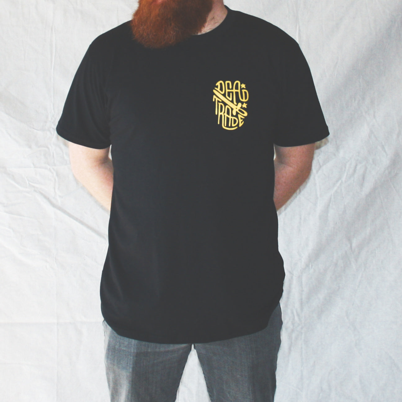 Black graphic t-shirt made in Canada from a soft 100% ring-spun cotton, featuring a bold hand-drawn design of a smiling skeleton holding a switchblade with the words “stay gold,” screen printed in yellow ink. Perfect for those who appreciate lowbrow, edgy artwork.